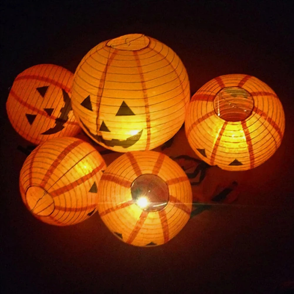 Set of Halloween-themed paper lanterns with jack-o'-lantern faces on a dark background.