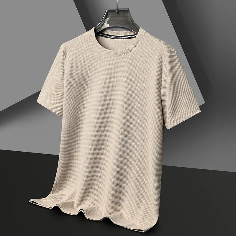 Beige t-shirt on a hanger against a gray background