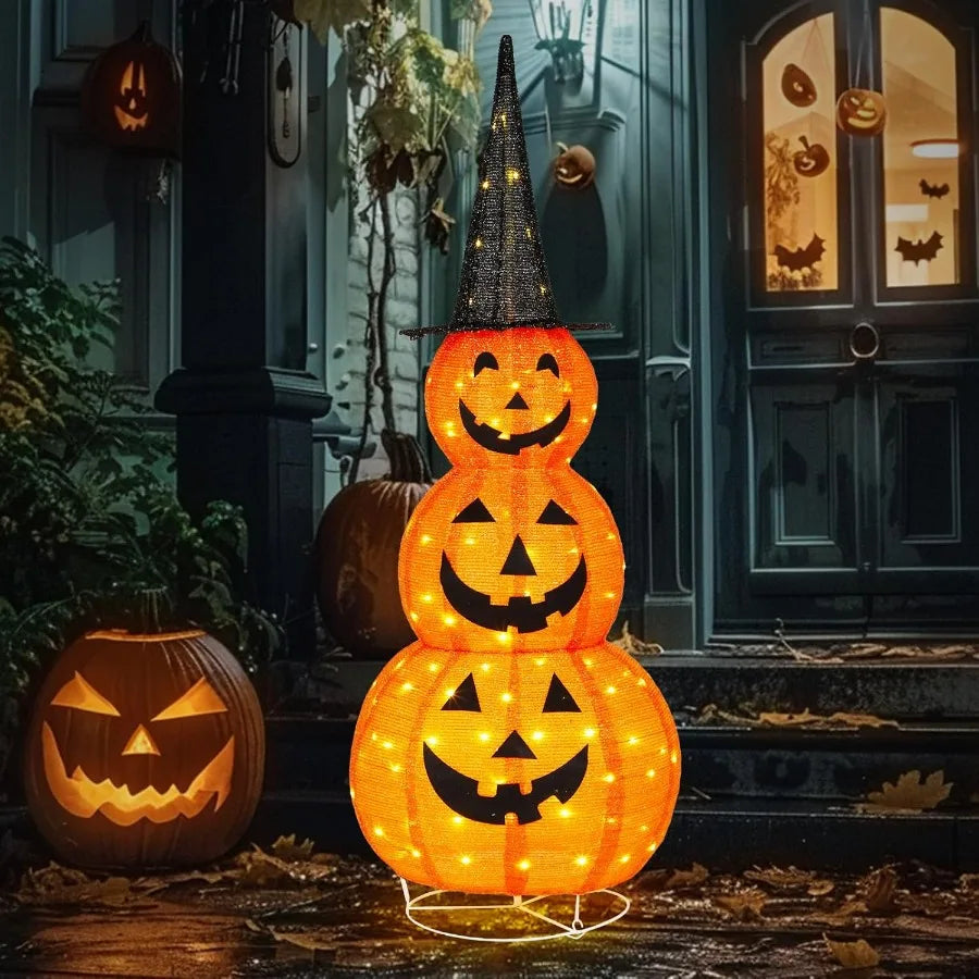 Stacked Halloween pumpkin lights with glowing faces in front of a door with carved pumpkins.