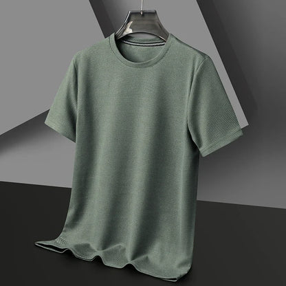 Green t-shirt on a hanger against a gray background