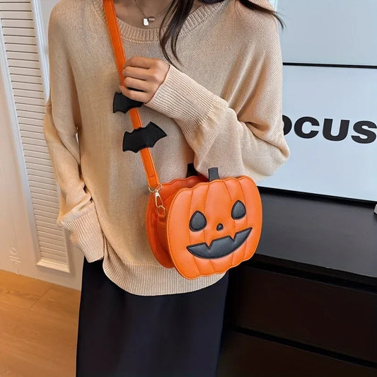 Person wearing a beige sweater holding an orange pumpkin-shaped bag with black bat decorations.